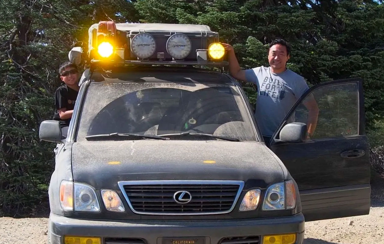 A family leans out of their overland vehicle.