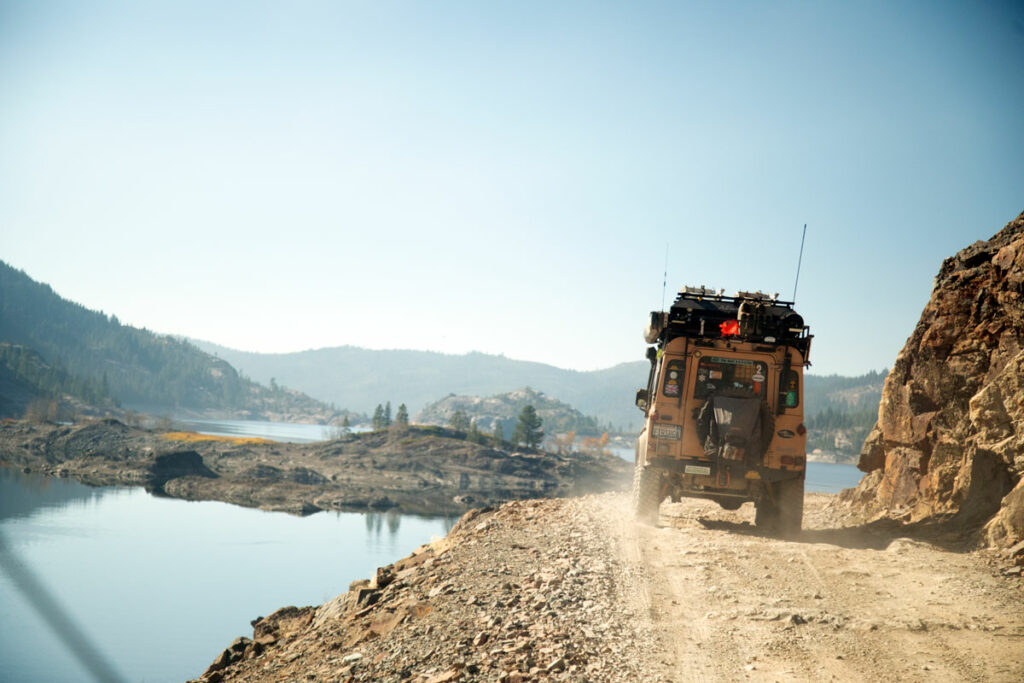 Land Rover Defender on a dirt shelf road.