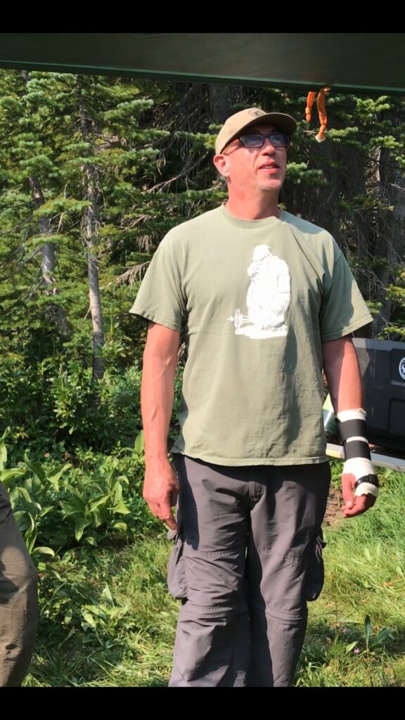 A man stands looking upward while outdoors.