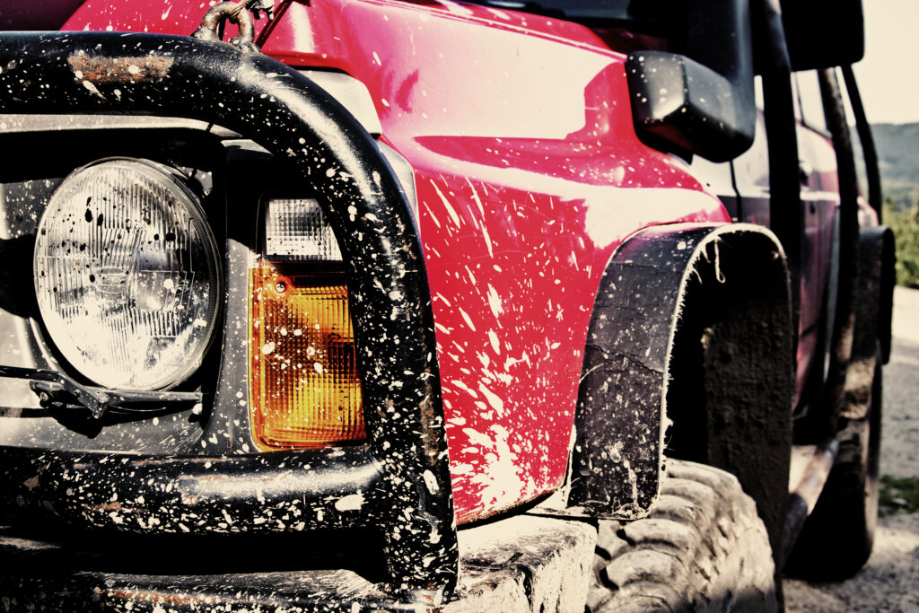 A vehicle splattered with mud from traveling off road