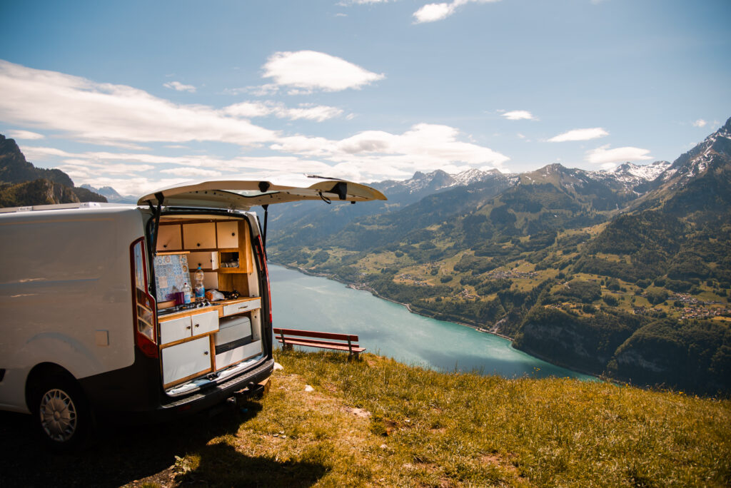 A van with minimal shelving and organization perched on a cliffside.