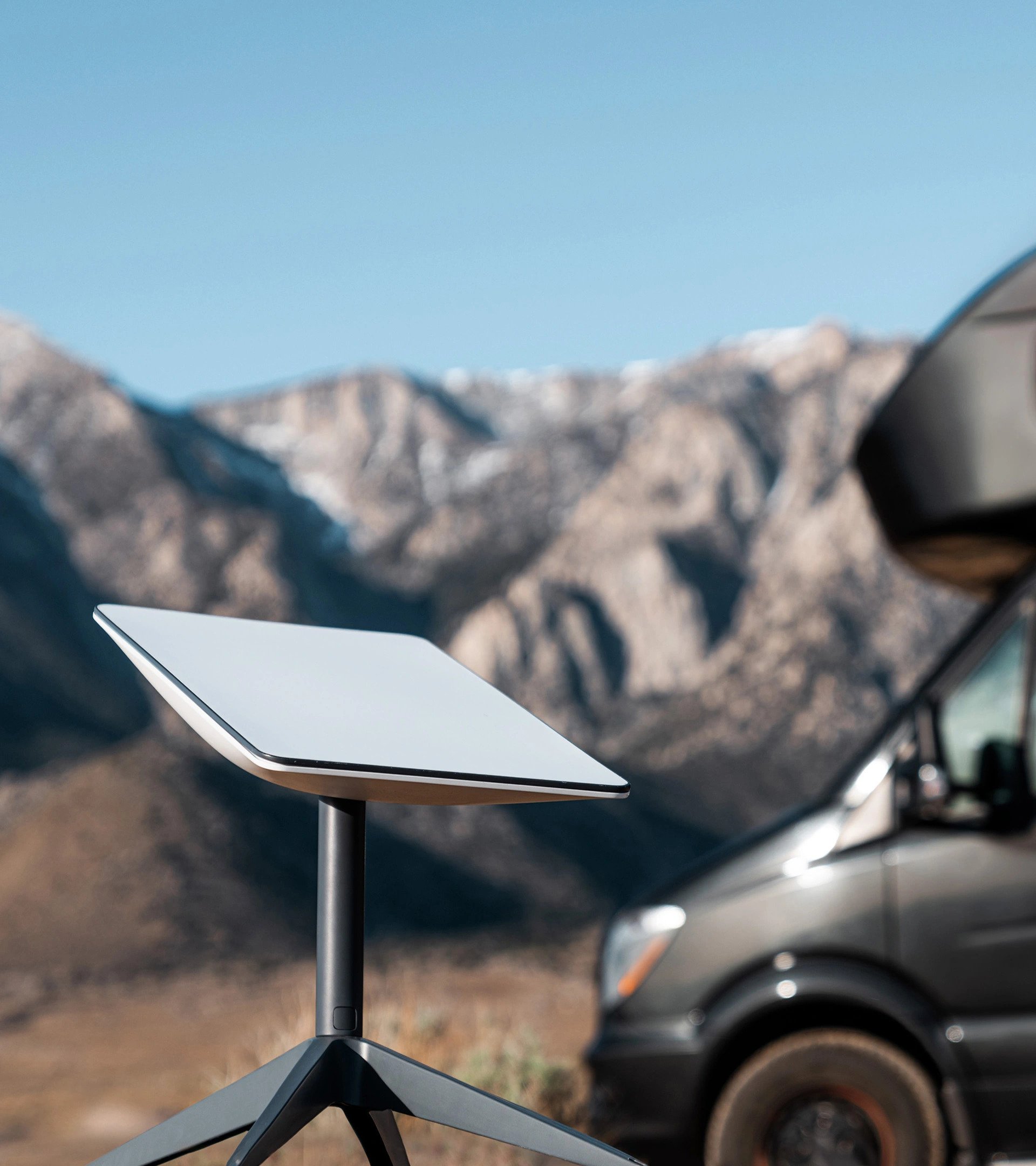 Starlink dish in front of a van.